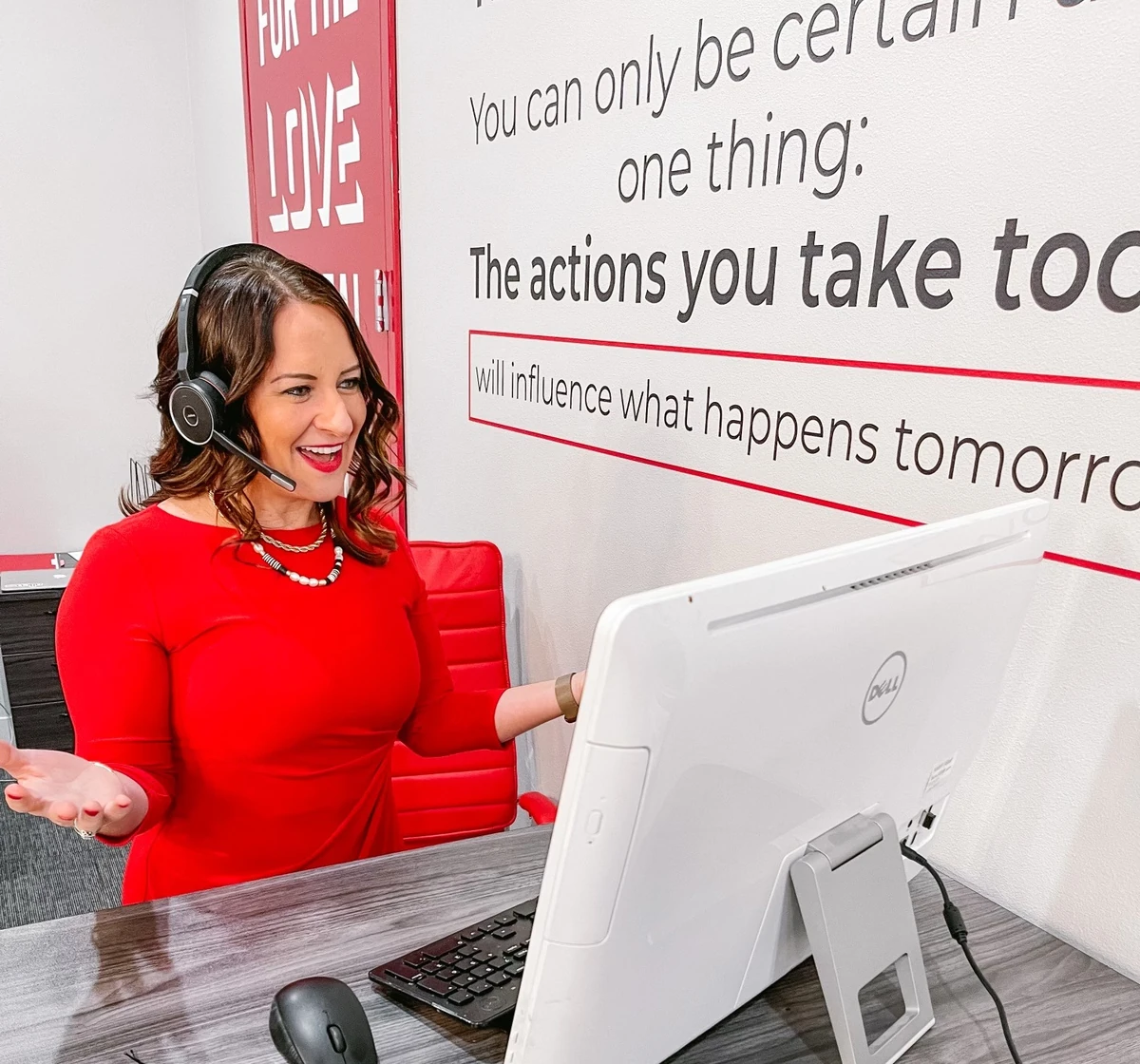 Tara Allen at her desk wearing a headset and making calls
